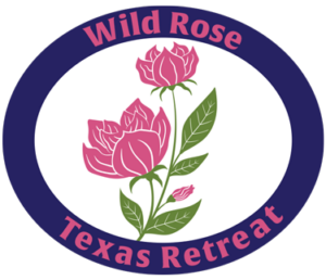Logo for Wild Rose Texas Retreat, dark blue circle with pink rose inside circle