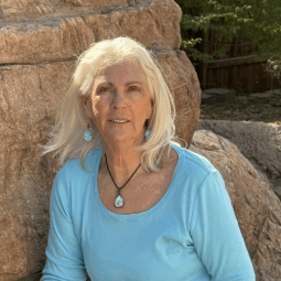 Rosemary in a blue shirt in front of a rock wall at the PHX Zoo