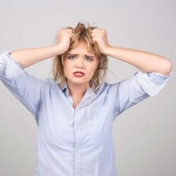 Afrazzled woman with blue eyes pulling hair